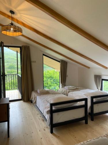 a large bedroom with a large bed and large windows at Guest House Shtili in Prezeti