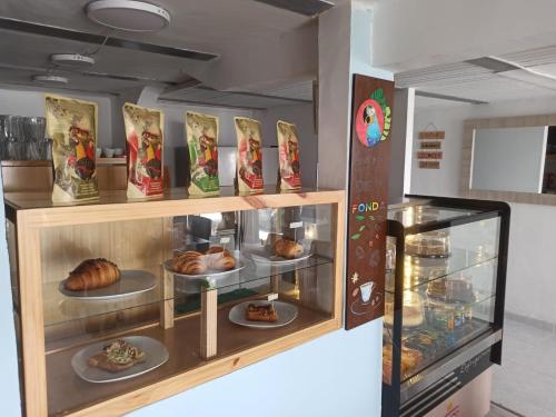 a display case in a bakery with plates of food at Hotel Mont Blanc in Circasia