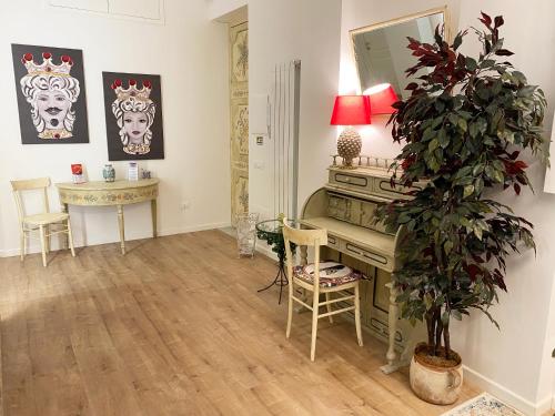 uma sala de estar com uma secretária e um vaso de plantas em Casa Granatelli em Palermo