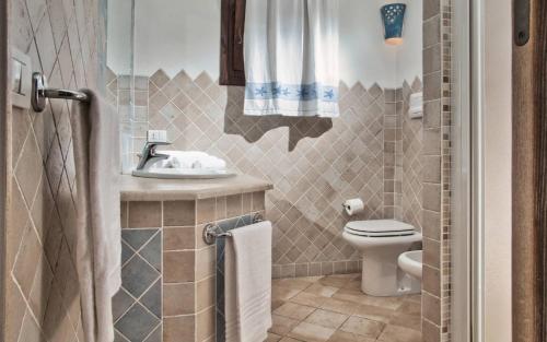 La salle de bains est pourvue de toilettes et d'un lavabo. dans l'établissement Vistamare Grande Pevero, à Porto Cervo