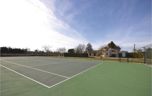 a tennis court with a house in the background at Cozy Home In Aubignan in Aubignan