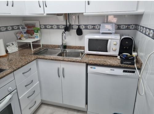 a small kitchen with a sink and a microwave at Cabo de Palos apartamento vacacional in Cabo de Palos