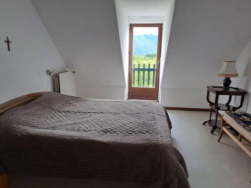 a bedroom with a bed and a window and a table at Grand appartement 4/5 personnes in Bartrés