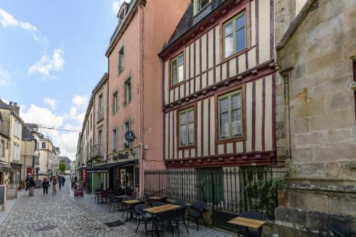 a street with a building with tables and chairs at Appartement T2 - Vue imprenable sur la cathédrale in Quimper