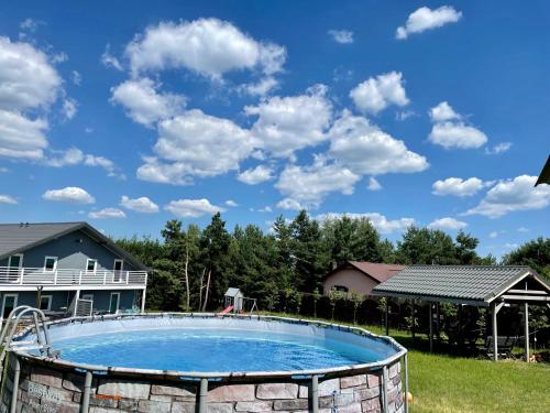 uma piscina num quintal com um céu azul em Sielsko-Anielsko Kobyla Góra em Ligota