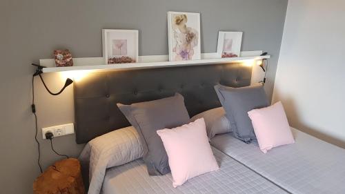 a bed with pink and blue pillows on it at Casa con piscina y jardin privado OASIS DE DOLORS in Puig-Gros