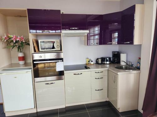 a kitchen with white cabinets and a stove top oven at Kiljan Apartments & Rooms in Blönduós