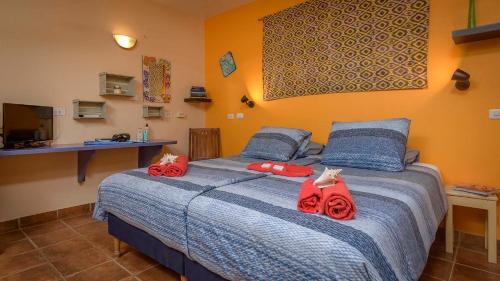 Un dormitorio con una cama con rosas rojas. en Djambo, en Kralendijk