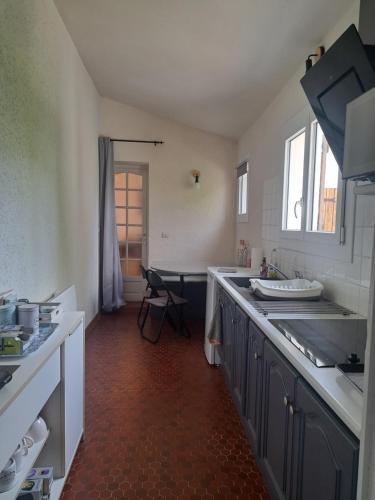 a kitchen with a sink and a counter top at Studio avec jardin à 5 min du Parc Walibi in Roquefort