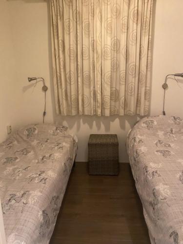 1 dormitorio con 2 camas individuales y ventana en Chalet, en Nistelrode