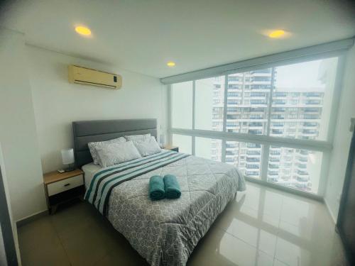 a bedroom with a bed with two shoes on it at Apartamento cerca al mar, terraza con vista 360 in Santa Marta