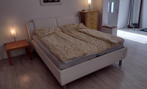 uma cama num quarto com uma mesa de cabeceira e uma mesa em Kleines gemütliches Apartment in zentraler Lage em Prien am Chiemsee