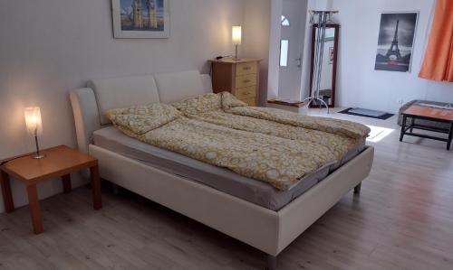 uma cama num quarto com uma mesa e um candeeiro em Kleines gemütliches Apartment in zentraler Lage em Prien am Chiemsee