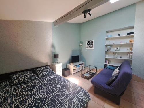 a bedroom with a bed and a chair in it at Studio avec jardin à 5 min du Parc Walibi in Roquefort