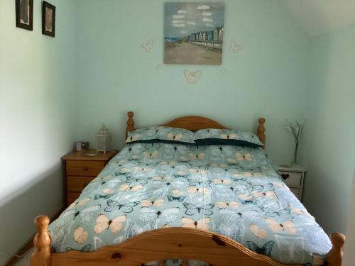 a bedroom with a bed with a blue comforter at Riverview Apartment in Buncrana