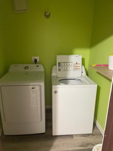 una lavadora y una lavadora en una sala verde en Uptown Motel, en Estevan