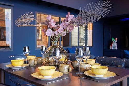 une table avec un vase avec des fleurs roses dans l'établissement Le Splendide by Connexion, à Cannes