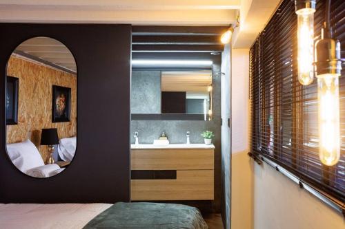 - une chambre avec un miroir, un lavabo et un lit dans l'établissement Le Splendide by Connexion, à Cannes