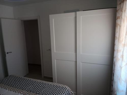 a bedroom with white cabinets and a bed in it at Siorica Beach in Matalascañas
