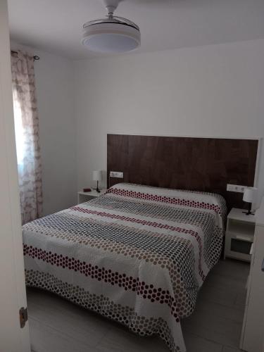 a bedroom with a bed with a red and white blanket at Siorica Beach in Matalascañas