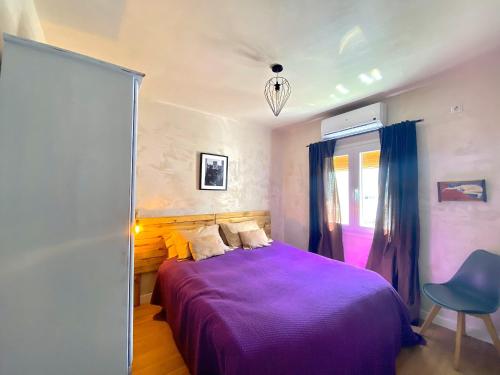 ein Schlafzimmer mit einem lila Bett und einem blauen Stuhl in der Unterkunft Junto al casco antiguo con terraza in Sevilla