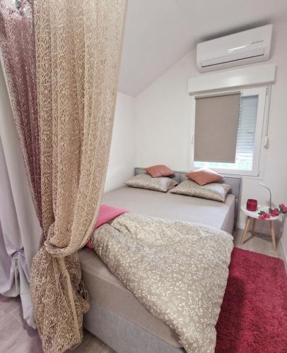 a bedroom with two beds with curtains and a window at STUDIO APP & Beauty Loza in Zambratija