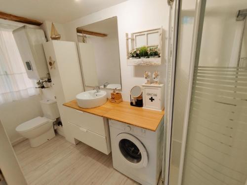 een badkamer met een wastafel en een wasmachine bij Bonito Apartamento Mundaka EBI-82 in Mundaka