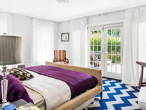 um quarto com uma cama grande e uma janela em Villa Southampton Village em Southampton