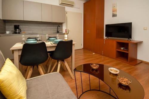 sala de estar con sofá y mesa con sillas en Apartments4You en Vodice