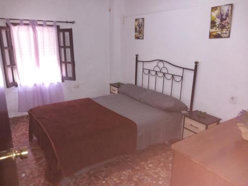 1 dormitorio con cama y ventana en Los Duendes, en El Puerto de Santa María