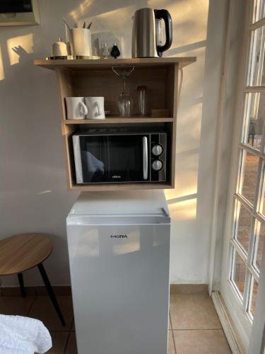 a microwave on top of a refrigerator in a kitchen at LuxuryAirportLodge near OR TAMBO in Kempton Park