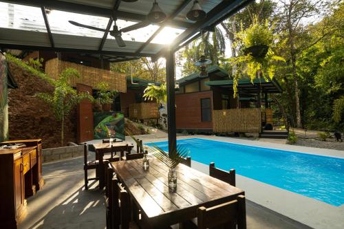 a patio with a table and a swimming pool at Riverside Villas in Manuel Antonio