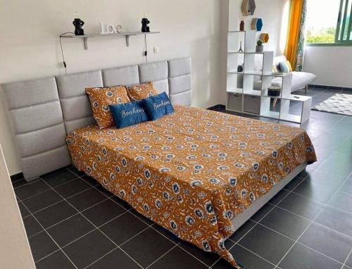 勒唐蓬的住宿－Studio cosy - Situé au Tampon，一间卧室配有一张带蓝色枕头的大床