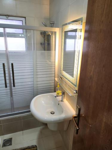 La salle de bains est pourvue d'un lavabo blanc et d'une fenêtre. dans l'établissement Rana's apartment, à Amman