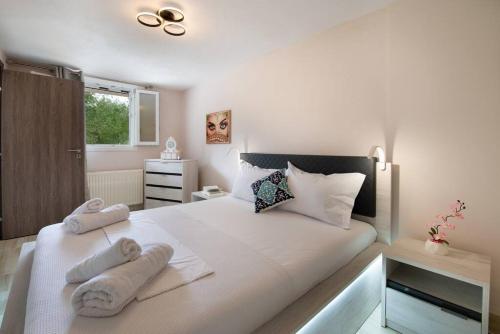 um quarto com uma grande cama branca com toalhas em Porto Gaios House em Gaios