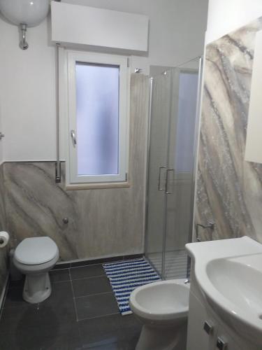 baño con ducha y aseo y ventana en Affittacamere Casa Flora en Peschici