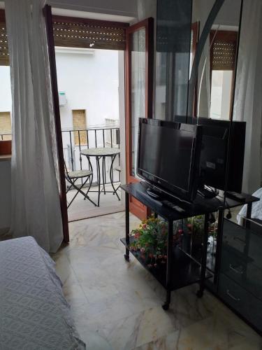 a television on a table in a room with a balcony at Affittacamere Casa Flora in Peschici