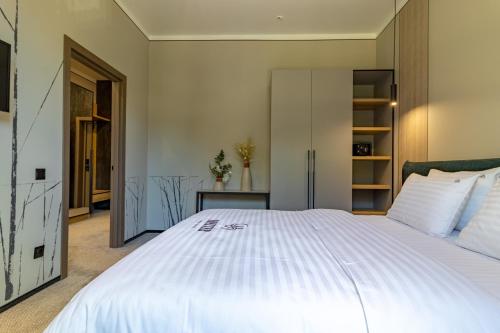a bedroom with a large white bed in a room at Shelter Apart Hotel in Bukovel