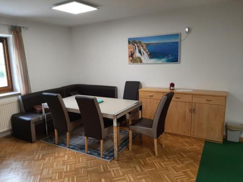 a dining room with a table and chairs and a desk at Schöne Wohnung am Bauernhof in Lehen