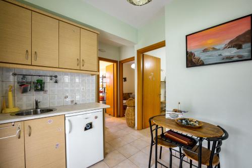 a kitchen with a sink and a table with chairs at Harmony villa in Sivota