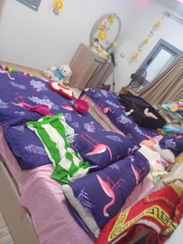 1 cama en un dormitorio con edredón y almohadas en ڤيلا فاخره في مدينة طنطا, en Tanta