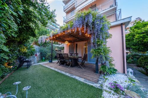 a garden with a wooden deck with a table and flowers at H11 COUNTRY LUX - Sanremo - Garden in Sanremo