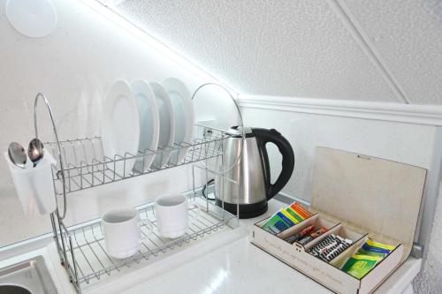 a shelf above a sink with plates and cups at Discovery Apartment Bansko in Bansko
