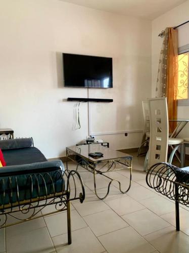 - une chambre avec un lit, une table et une télévision dans l'établissement LNIMMO - DEMGIEU - Studio meublé sécurisé climatisé et internet illimité avec forage, à Yaoundé