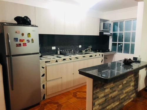 a kitchen with a stainless steel refrigerator and a stove at Casa ISABELLA - Playa dormida in Santa Marta