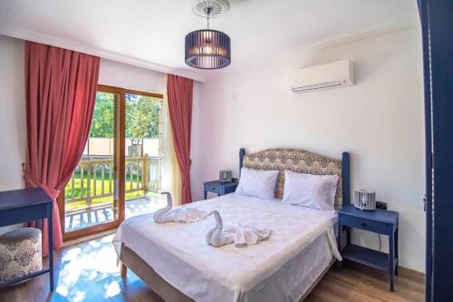 a bedroom with a bed with two swans on it at Kayaköyde Havuzlu Bahçeli Villa in Fethiye