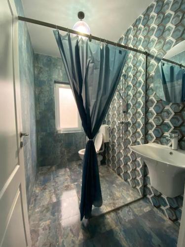 a bathroom with a sink and a shower curtain at Casa Ortviken in Eforie Sud