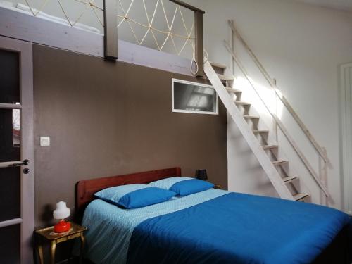 sypialnia z niebieskim łóżkiem i schodami w obiekcie Balad'âne w mieście Flachères