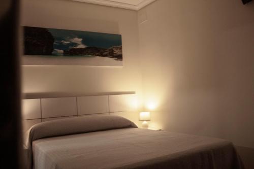 a bedroom with a bed and a painting on the wall at Rural El Bosque in Entrambasaguas