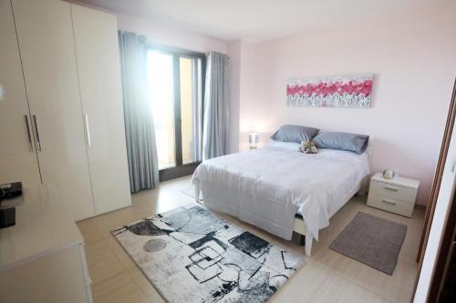 - une chambre blanche avec un lit et un tapis dans l'établissement Immaculate house with panoramic views, à Casarano